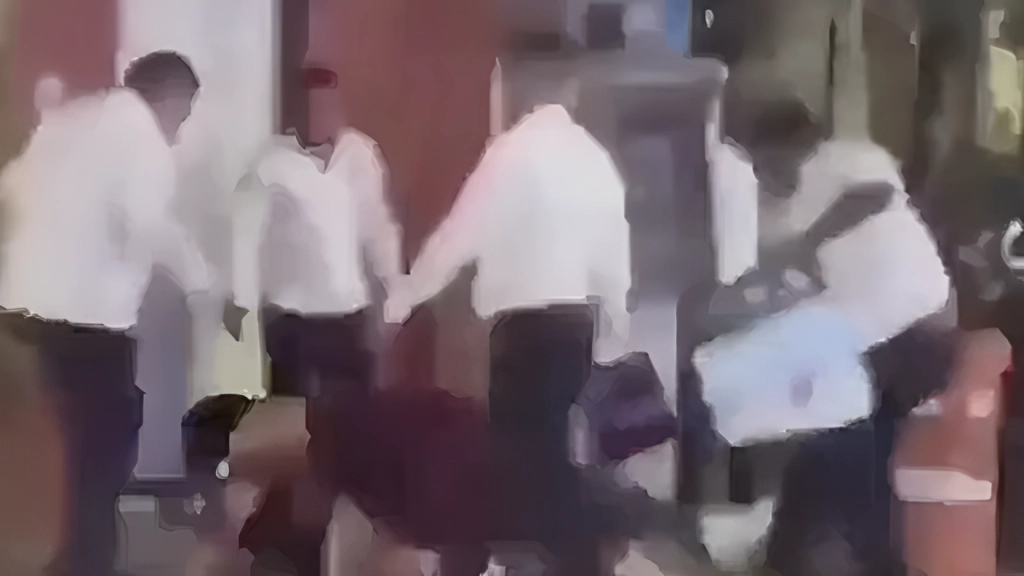 En el video se observa como los taxistas le pegan al hombre con un objeto, lo tiran al suelo y patean mientras su acompañante grita e intenta protegerlo cubriéndolo con su cuerpo, sin embargo, los taxistas continúan dándole de patadas. Imagen tomada de un video difundido en redes sociales