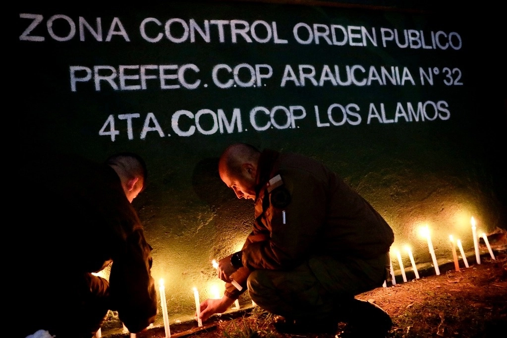 Agentes de policía encienden velas durante una vigilia por sus colegas asesinados en Cañete, Chile, el sábado 27 de abril de 2024. Asaltantes armados tendieron una emboscada y mataron a tres agentes del orden en el sur de Chile el sábado antes de prender fuego a su automóvil, dijeron las autoridades. Foto Ap