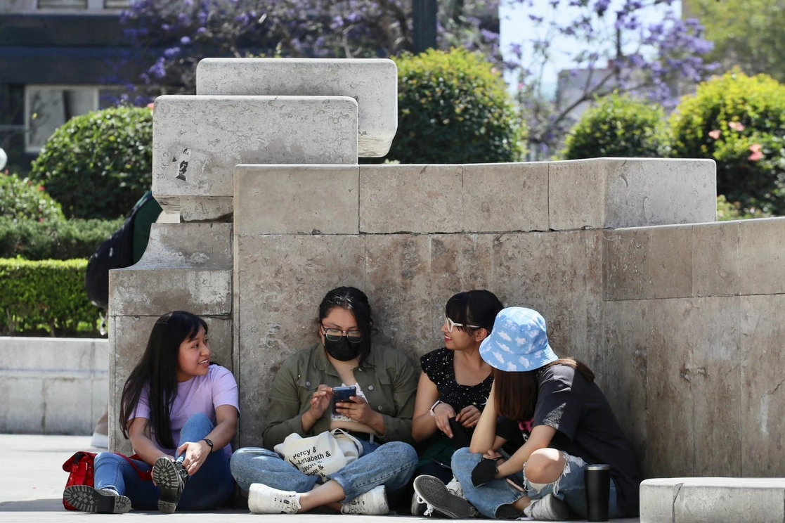 Jóvenes buscan sombra para protegerse de las altas temperaturas que se registran en la Ciudad de México, el 6 de marzo de 2023. Foto Roberto García Ortiz
