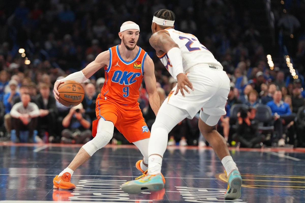 El base del Oklahoma City Thunder, Alex Caruso, a la izquierda, busca una oportunidad ante el base de los Phoenix Suns, Jalen Green, a la derecha, durante la segunda mitad de un partido de baloncesto de la Copa NBA, el miércoles 10 de diciembre de 2025, en Oklahoma City. Foto