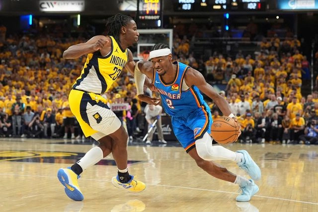 El basquetbolista del Oklahoma City Thunder, Shai Gilgeous-Alexander (der) durante un duelo ante Aaron Nesmith (izq) de los Indiana Pacers. Foto 