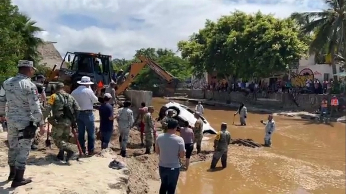 Personal del Ejército rescató uno de los seis vehículos que fueron arrastrados por la corriente a la playa de Sayulita, Nayarit, luego de las lluvias que provocó la depresión tropical ‘Lester’. Foto ‘La Jornada’