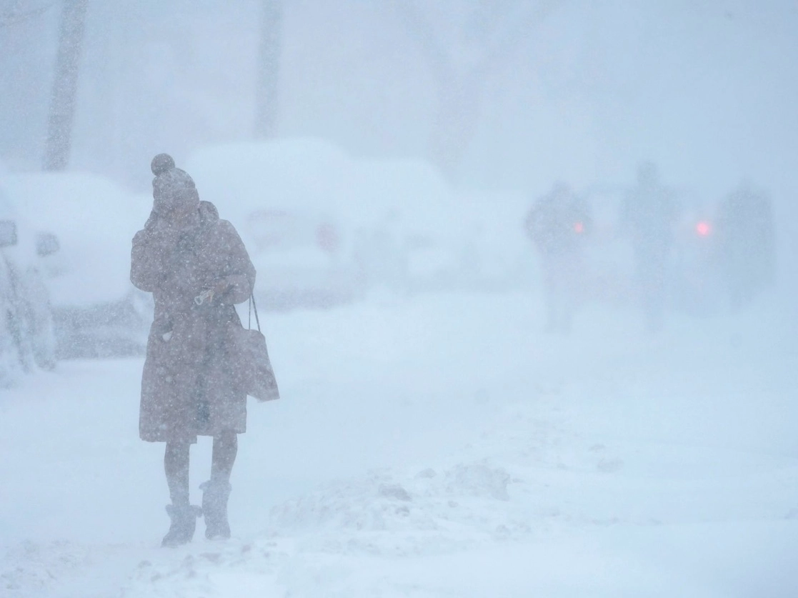 Una mujer intenta protegerse la cara de la nieve mientras camina en una calle cubierta de nieve en Jersey City, Nueva Jersey, el 1 de febrero de 2021. Foto Ap