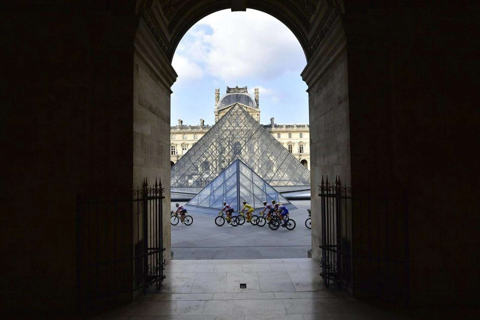 Ciclistas recorre el patio del museo del Louvre de París en 2020. Foto Ap