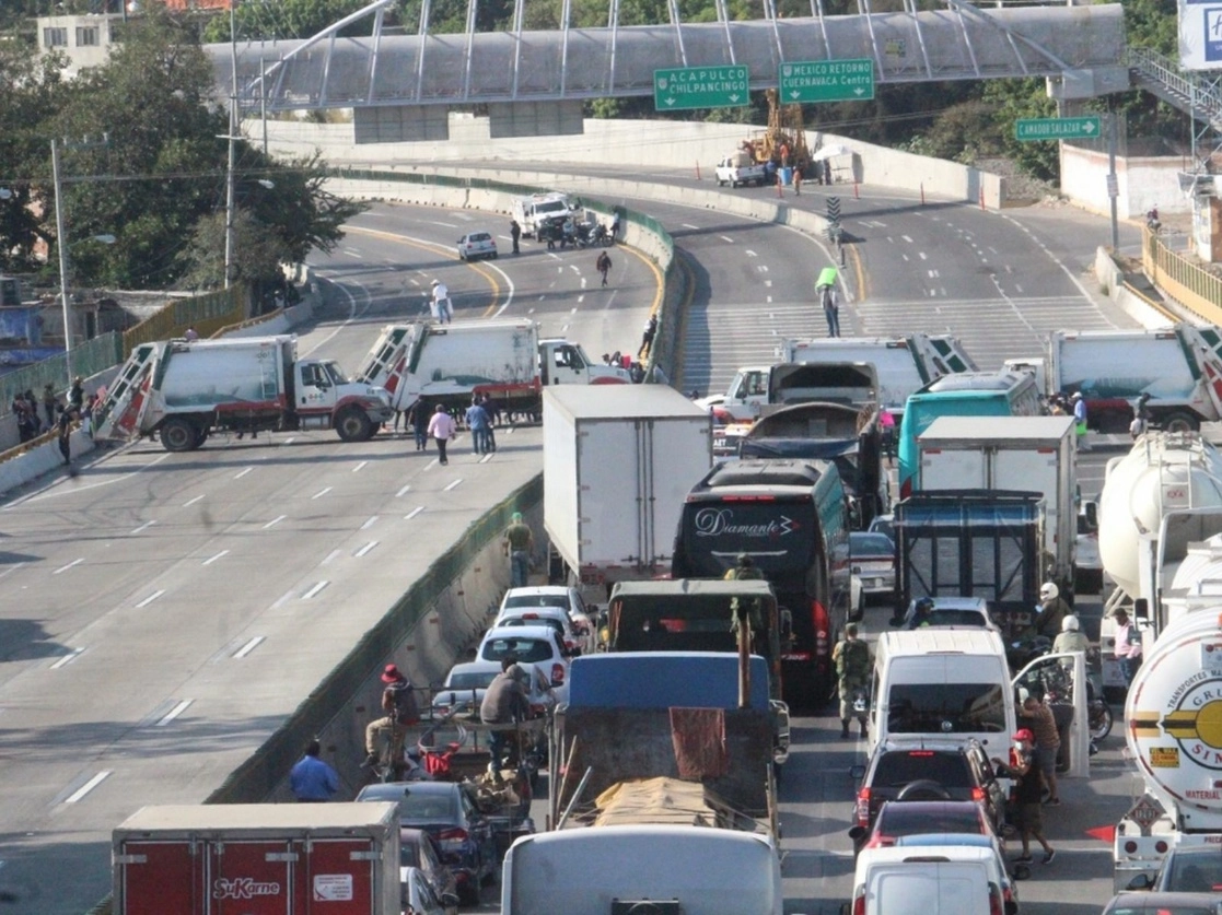 Los manifestantes bloquearon la autopista del Sol, a la altura del paso Exprés, con unidades de recolecta de basura, las cuales dejaran de operar esta semana debido a la falta de recursos. Foto Rubicela Morelos