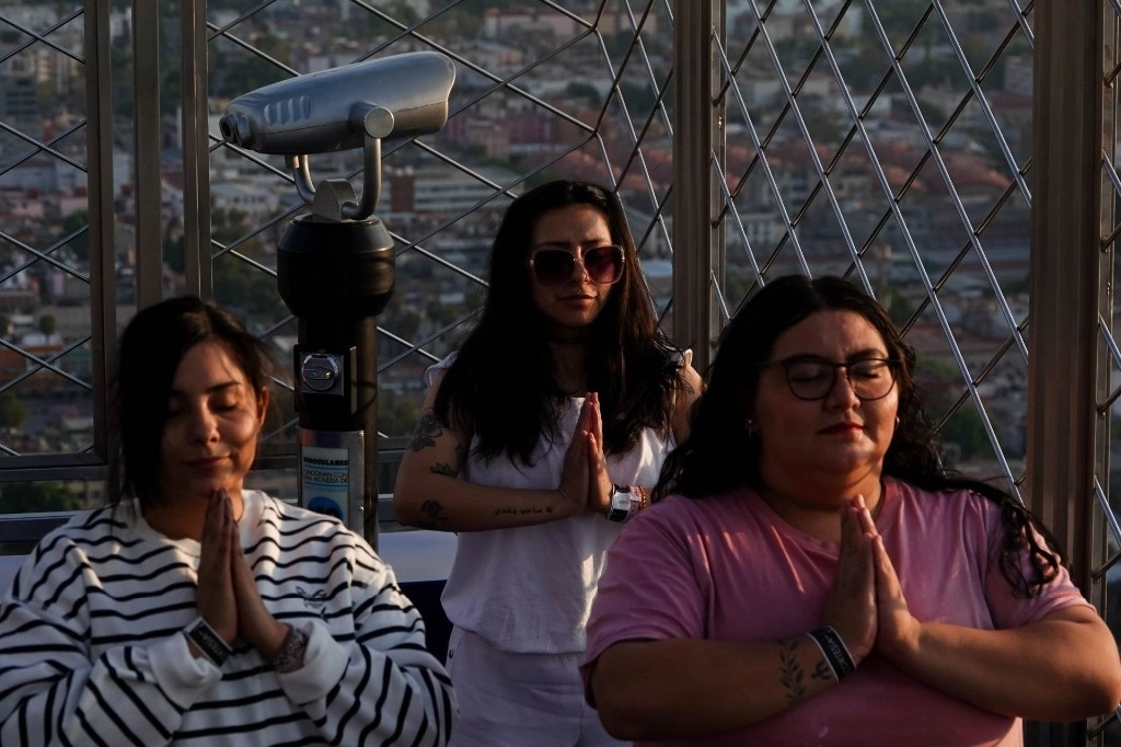 Mujeres durante una clase especial de yoga y meditación en la parte alta de la Torre Latinoamericana, en CDMX. Foto Cuartoscuro 