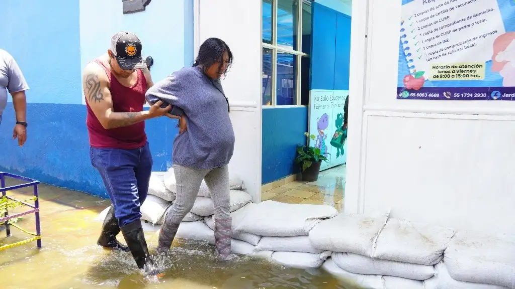 Una mujer embarazada es auxiliada para trasladarse en el área afectada de Chalco. Foto Daniel Ramón