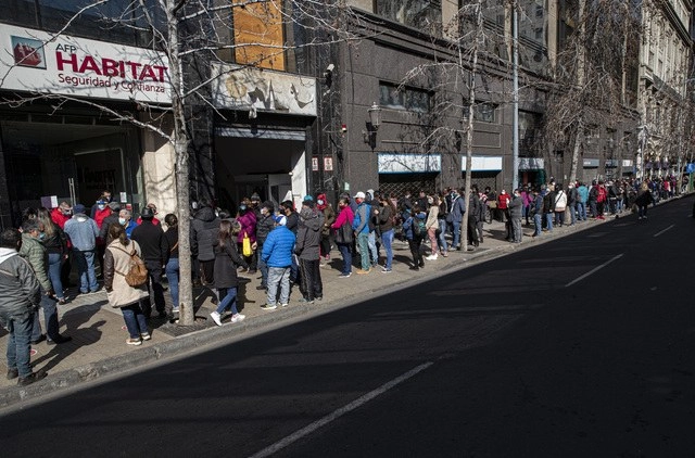 Las filas en los locales comerciales fueron organizados por la Policía y guardias privados para evitar aglomeraciones en el centro de Santiago, en Chile. Foto Ap 