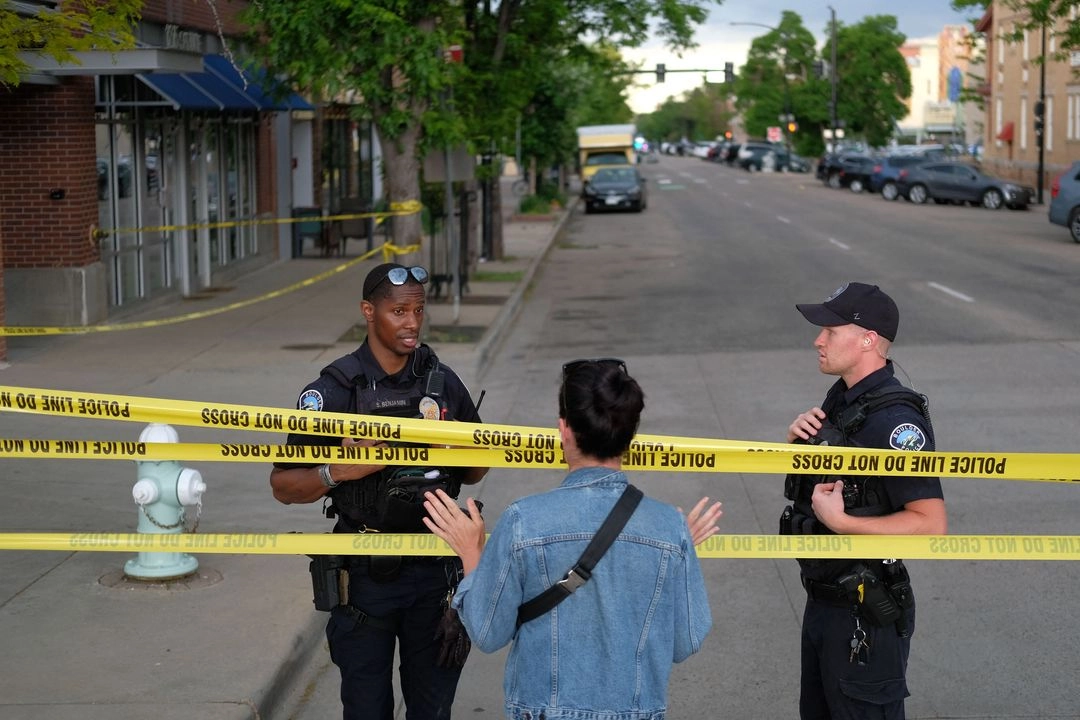 Agentes de policía conversan con un transeúnte en el lugar de un ataque contra manifestantes que exigían la liberación de rehenes israelíes retenidos en Gaza, en la calle Pearl de Boulder, Colorado, EU, el 1° de junio de 2025. Foto