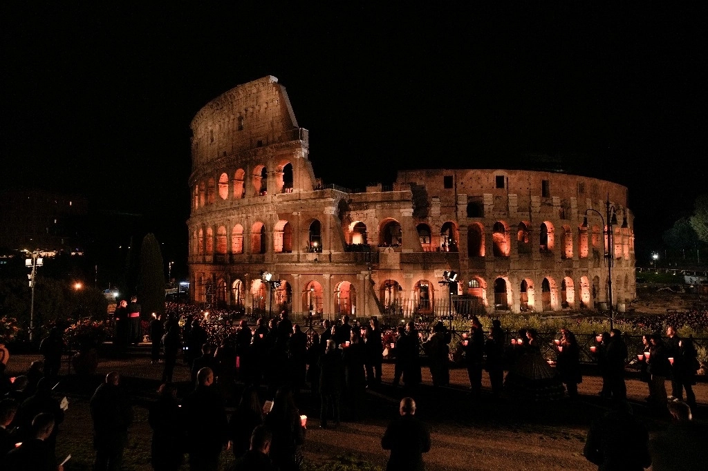 Personas sostienes velas durante la procesión con antorchas del Vía Crucis este Viernes Santo, en Roma. Foto Ap