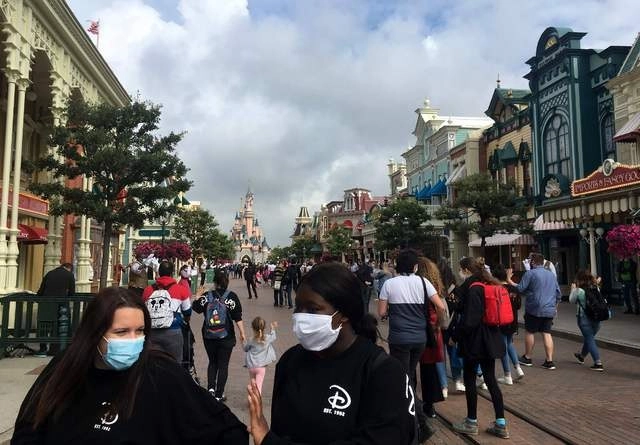 Con cubrebocas, visitantes recorren Disneyland París durante la reapertura del parque temático. Foto Afp
