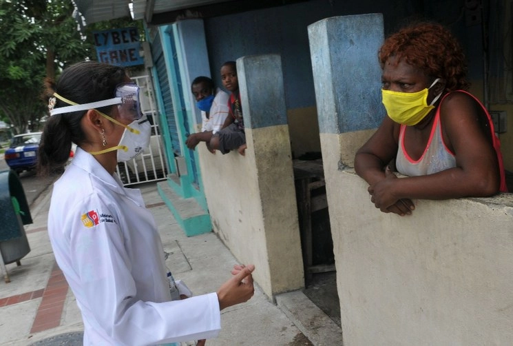 Una doctora habla con una mujer contagiada de Covid-19 en Ecuador. Foto Afp