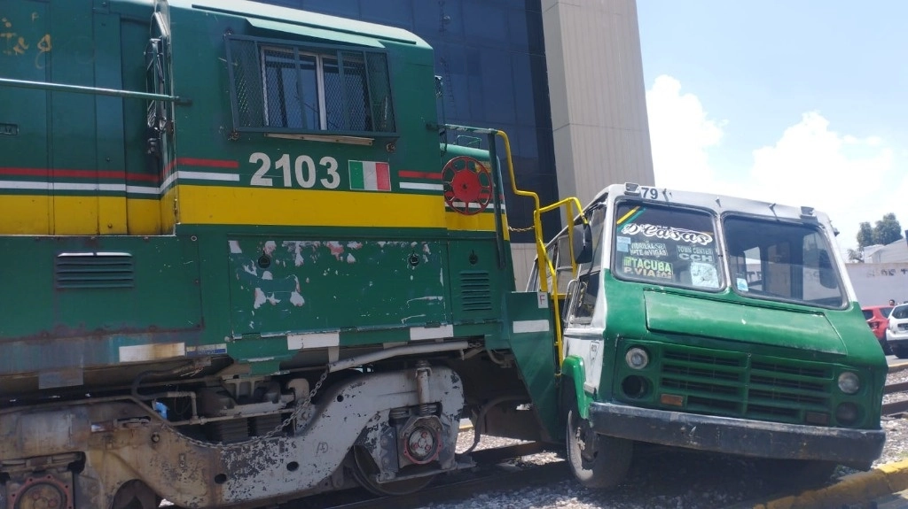 El microbus quedó prensado y abollado en su lado derecho por el tren. Foto 'La Jornada'   