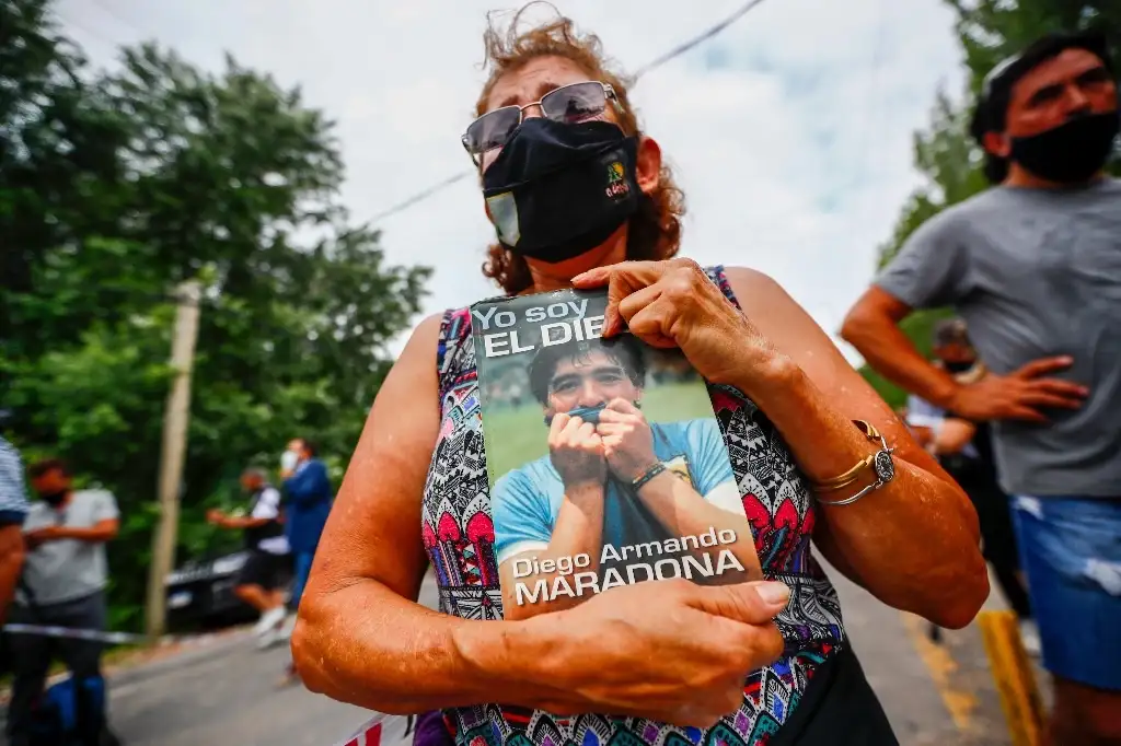 Una mujer con una imagen de Diego Armando Maradona, se une a los dolientes que salieron a las calles de Buenos Aires por la muerte del ex astro de futbol. Foto Ap  