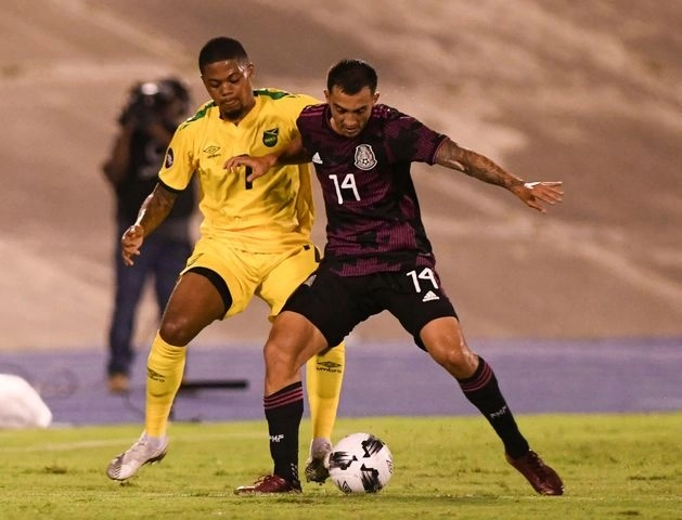 Los futbolistas de Jamaica, León Bailey (izq) y el mexicano Luis Chávez (c) durante una jugada en el encuentro. Foto Afp