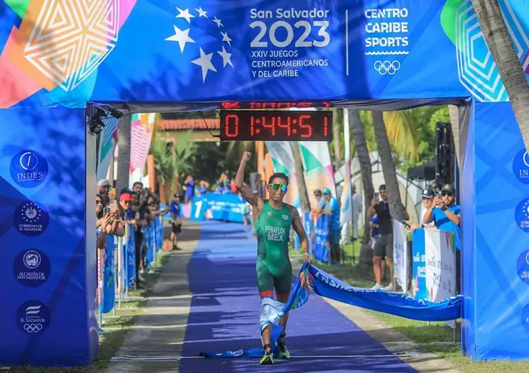 Los triatletas mexicanos tuvieron una destacada participación en los Juegos Centroamericanos y del Caribe 2023 al subir al podio en las categorías varonil y femenil con tres oros, dos platas y un bronce. En la imagen, Aram Peñaflores, quien se llevó el metal dorado al culminar la prueba en un tiempo de una hora 44 minutos y 51 segundos, el 5 de julio de 2023. Foto tomada de Twitter @SSalvador2023
