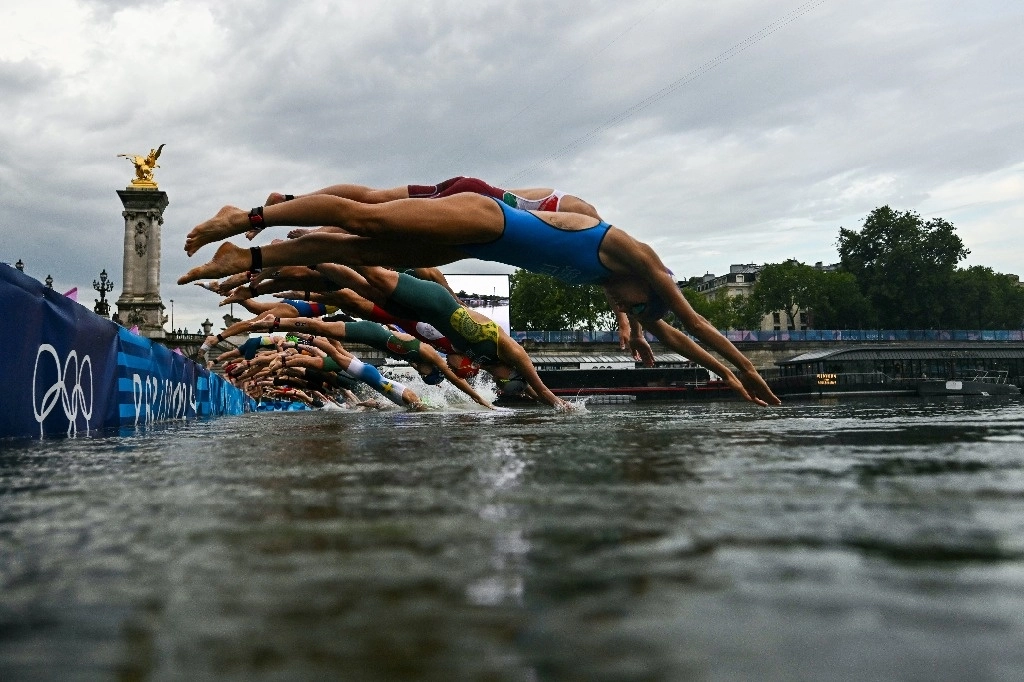 Atletas compiten en la carrera de natación en el río Sena durante la prueba individual femenina. Foto Xinhua  