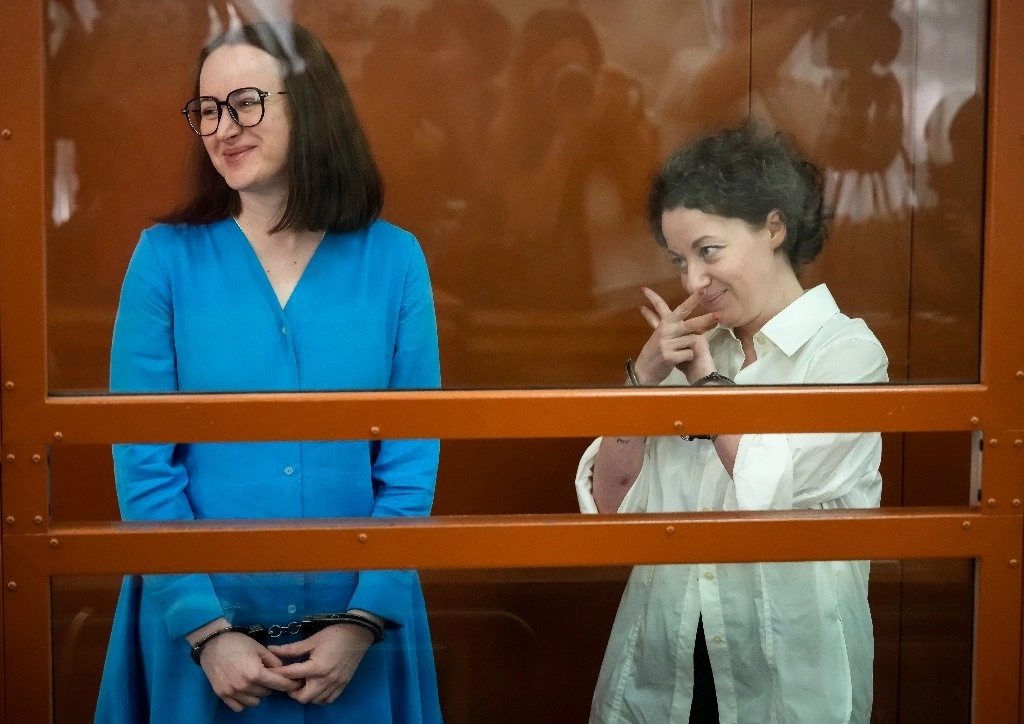 La directora de teatro Zhenya Berkovich (der.) hace gestos mientras está de pie con la dramaturga Svetlana Petriychuk en una caja de vidrio antes de una audiencia en un tribunal de Moscú, en la cual fueron sentenciadas a seis años de prisión, en Rusia, el 8 de julio de 2024. Foto Ap