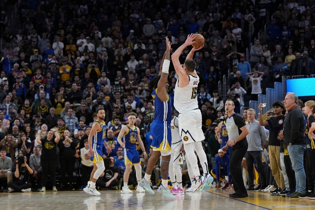Nicola Jokic realiza el lanzamiento de tres puntos que en los segundos finales le dio el triunfo a Nuggets de Denver sobre Golden State. Foto Ap.