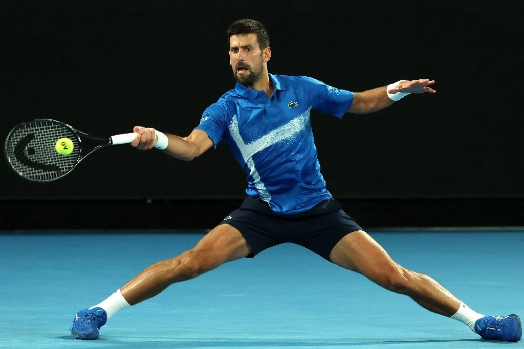 El serbio Novak Djokovic devuelve el balón al estadunidense Nishesh Basavareddy durante su partido individual masculino en el segundo día del torneo de tenis Abierto de Australia en Melbourne el 13 de enero de 2025. Foto Afp