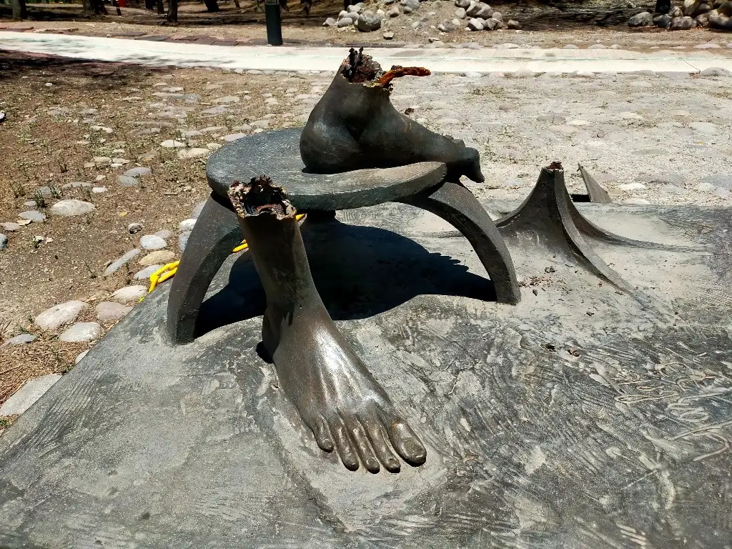Los pies delgados y largos de bronce, con exposición de la herrería interna, fracturada y tronchada, quedaron en el basamento de la estatua identificada como “Vendedor de Esperanzas” de la artista plástica originaria de Puebla, conocida como Charlotte Yazbek o como se llama realmente, Charlotte Mata Rascála, quien, durante la fundación del parque, en el año de 1976, donó 17 de sus obras a Cuautitlán Izcalli. Foto Silvia Chávez González