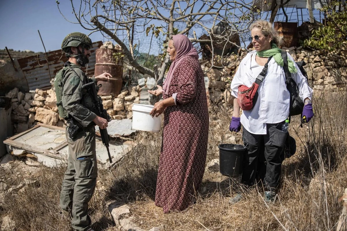 Un soldado israelí intenta detener la cosecha en un olivar palestino cerca del asentamiento israelí de Elazar, al sur de Belén, en la Cisjordania reocupada. Foto 