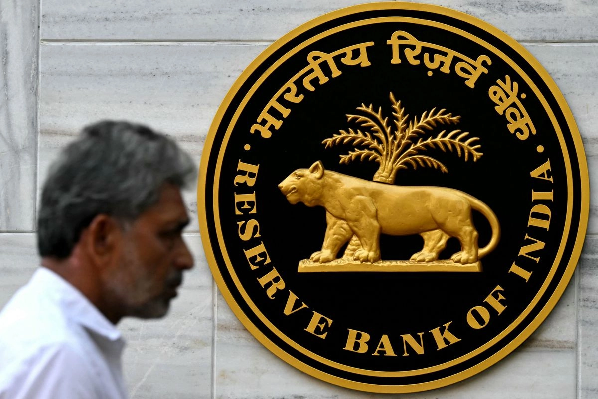 Un peatón pasa junto al logotipo del Banco de la Reserva de la India (RBI) afuera de su sede en Mumbai. 