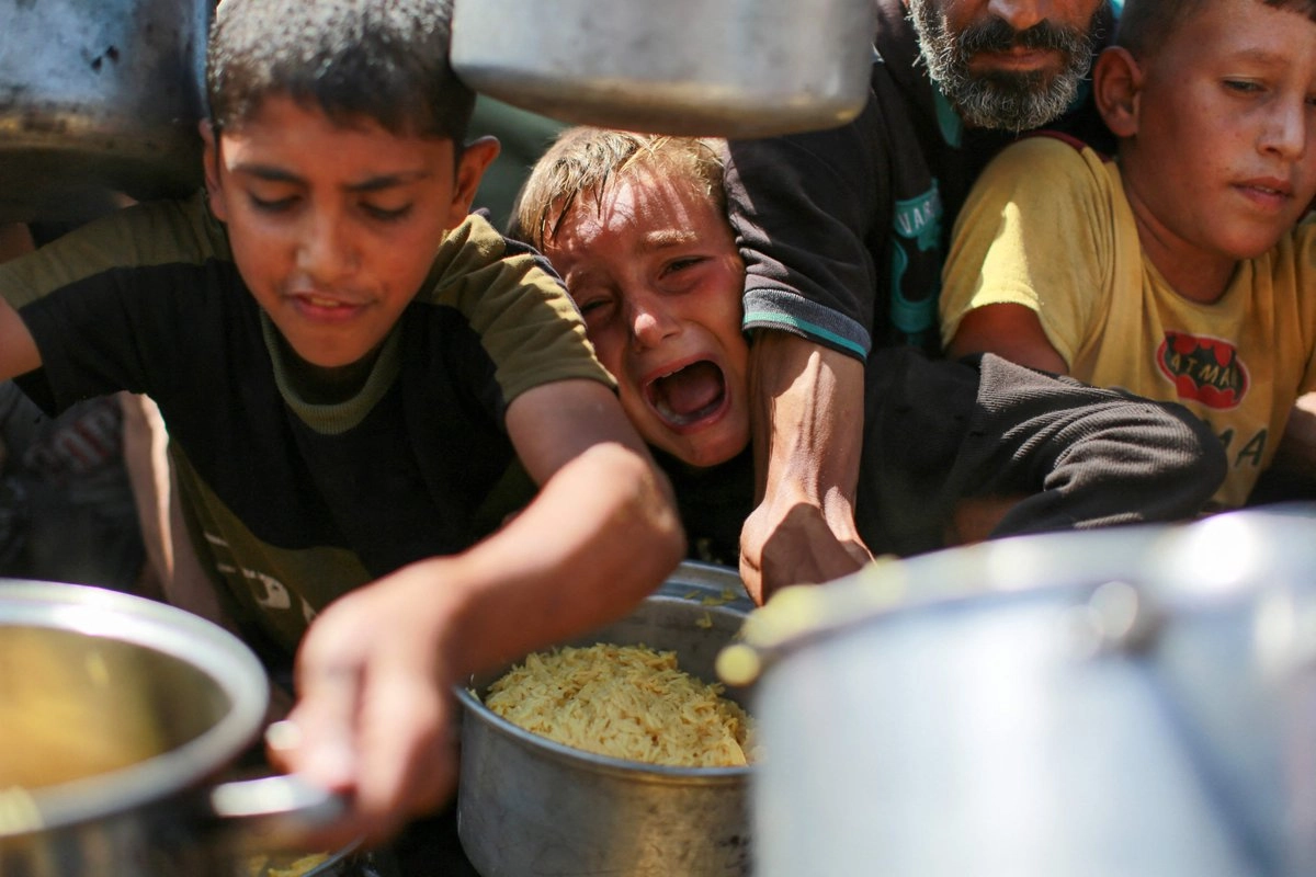  Unidos por la desgracia pero separados por el hambre, niños y adultos palestinos compiten todos los días por conseguir un poco de comida. En la imagen, a empujones, gritos y codazos se disputan un poco de arroz que deberán hacer rendir al máximo, pues la siguiente ración de alimentos podría tardar días. Foto