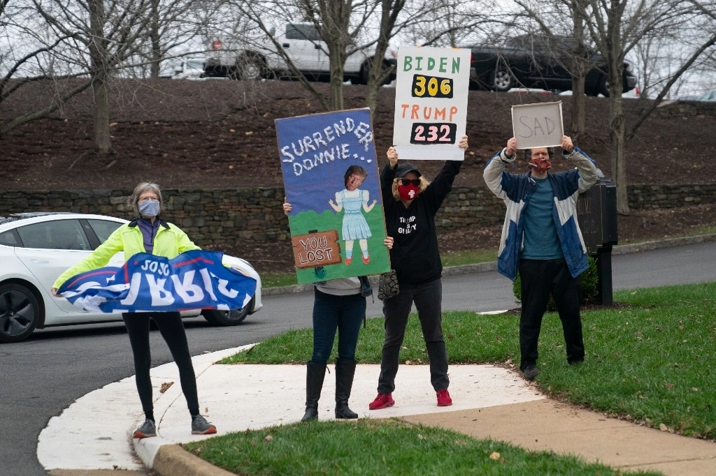 Protesta frente al Trump National Golf Club cuando llega el presidente Donald Trump, el domingo 15 de noviembre de 2020, en Sterling, Virginia. Foto Ap