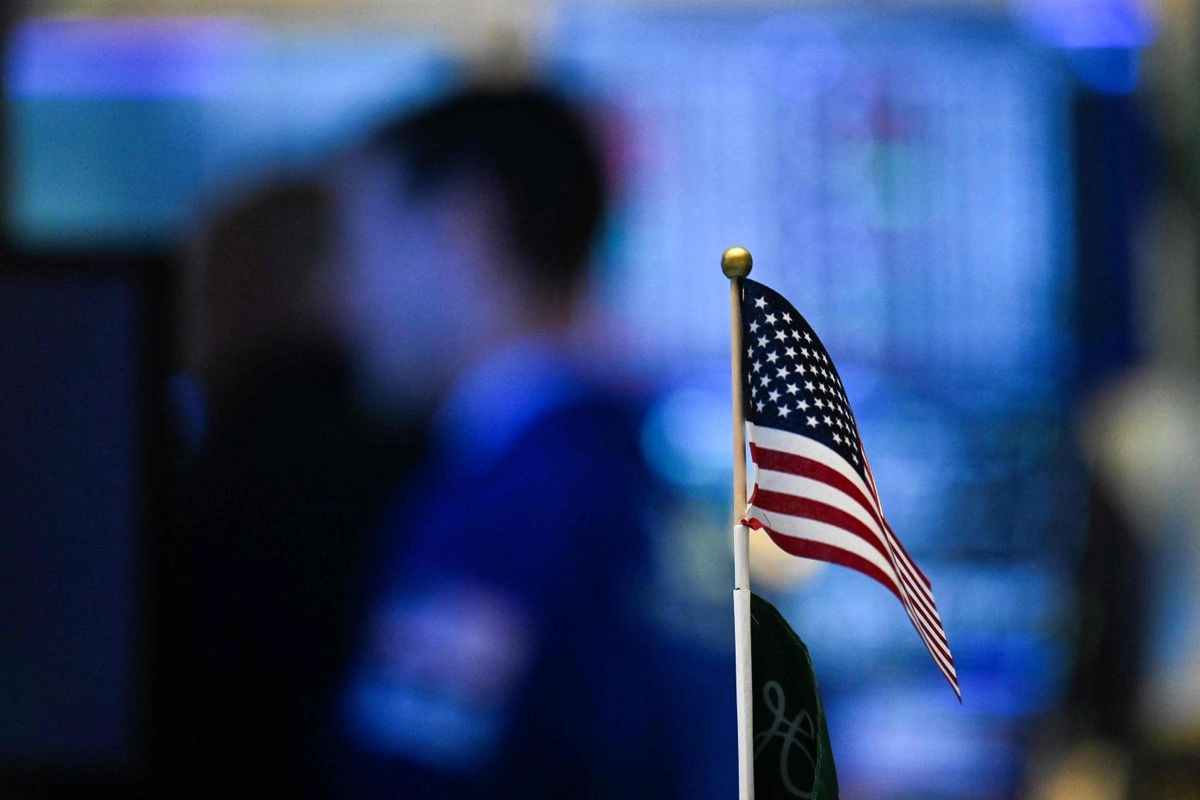 Una bandera estadunidense se exhibe sobre un escritorio en el parqué de la Bolsa de Valores de Nueva York (NYSE) al sonar la campana de apertura del 15 de julio de 2025 en la ciudad de Nueva York. Foto