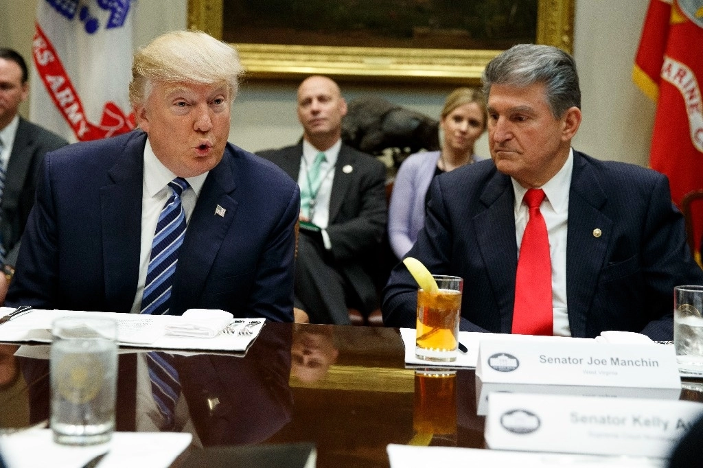 El senador Joe Manchin, demócrata por Virginia, a la derecha, escucha a la derecha mientras el entonces presidente Donald Trump habla durante una reunión con senadores en febrero de 2017. Foto Ap