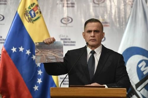 El fiscal general de Venezuela, Tarek William Saab, sostiene una foto de miles de balas incautadas en la fallida incursión extranjera. Foto Ap