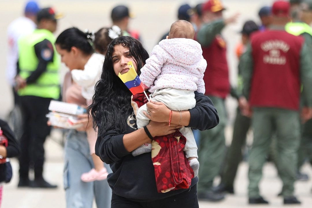 Una migrante venezolano camina con un bebé a su llegada al Aeropuerto Internacional Simón Bolívar en Maiquetía, Venezuela, el 20 de marzo de 2025. Foto 