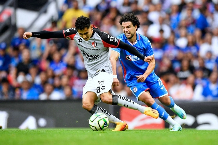 El rojinegro Ángel Márquez intenta escapar de la férrea marca del celeste José Ignacio Rivero, ayer durante el encuentro en el estadio Azteca. Foto Ap 