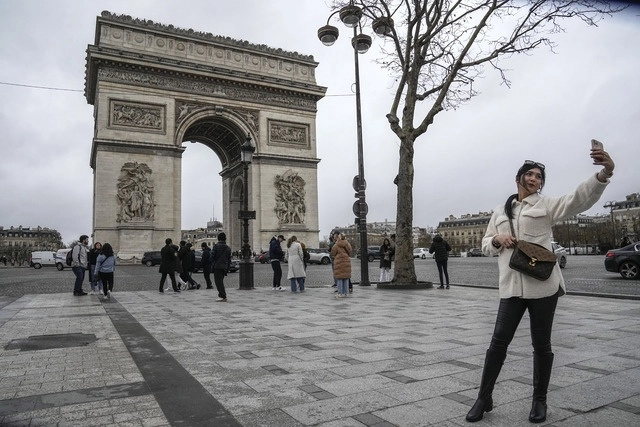 Una mujer se toma una fotografía frente al Arco del Triunfo en París, Francia. Foto Ap