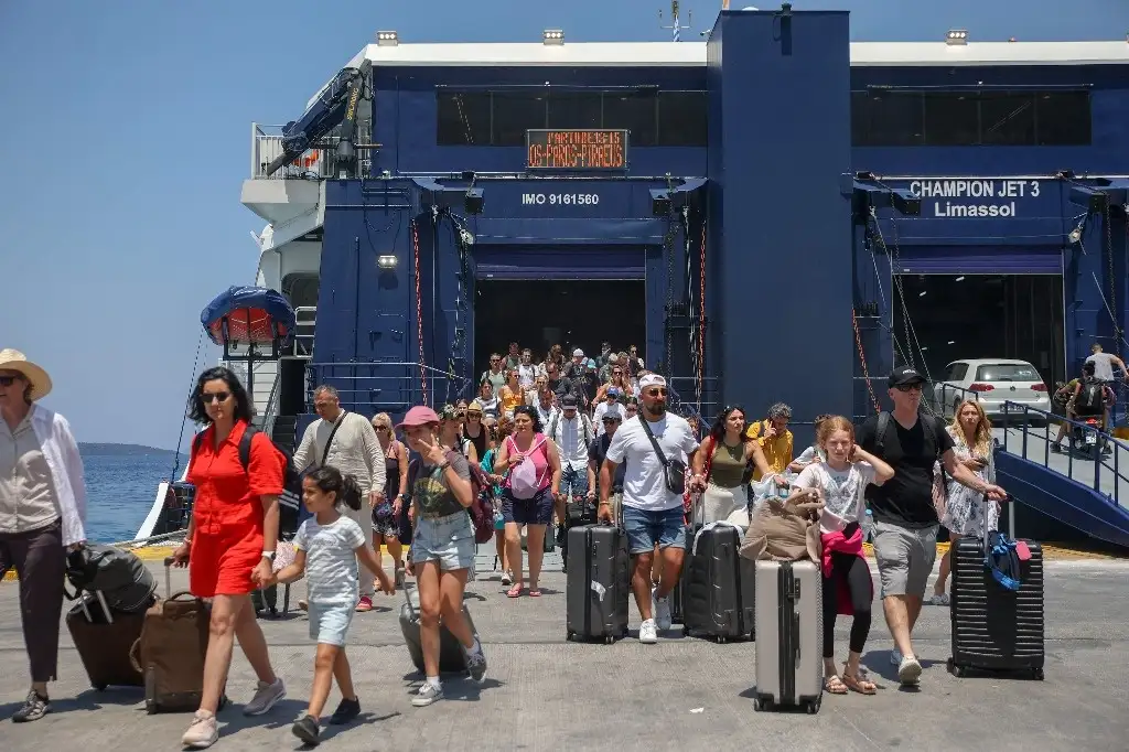Turistas desembarcan en la isla griega de Santorini. Al igual que otros destinos turísticos populares, ese lugar se está acercando a la sobresaturación y ahora quiere restringir el número de cruceros. Foto Afp 
