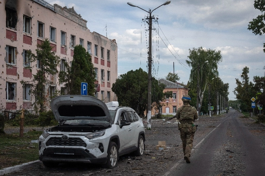 Soldado ucranio camina frente al ayuntamiento en Sudzha, en la región rusa de Kursk. Foto Ap