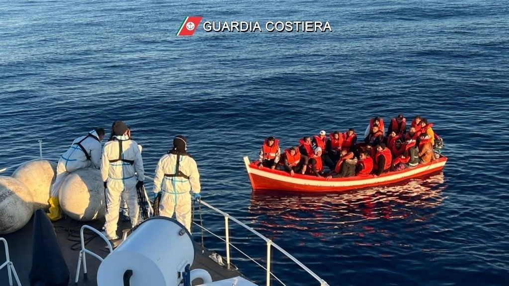 En imagen del 10 de abril pasado, miembros de la Guardia Costera auxilian a migrantes que viajaban en un pequeño bote, en aguas italianas. Foro Afp