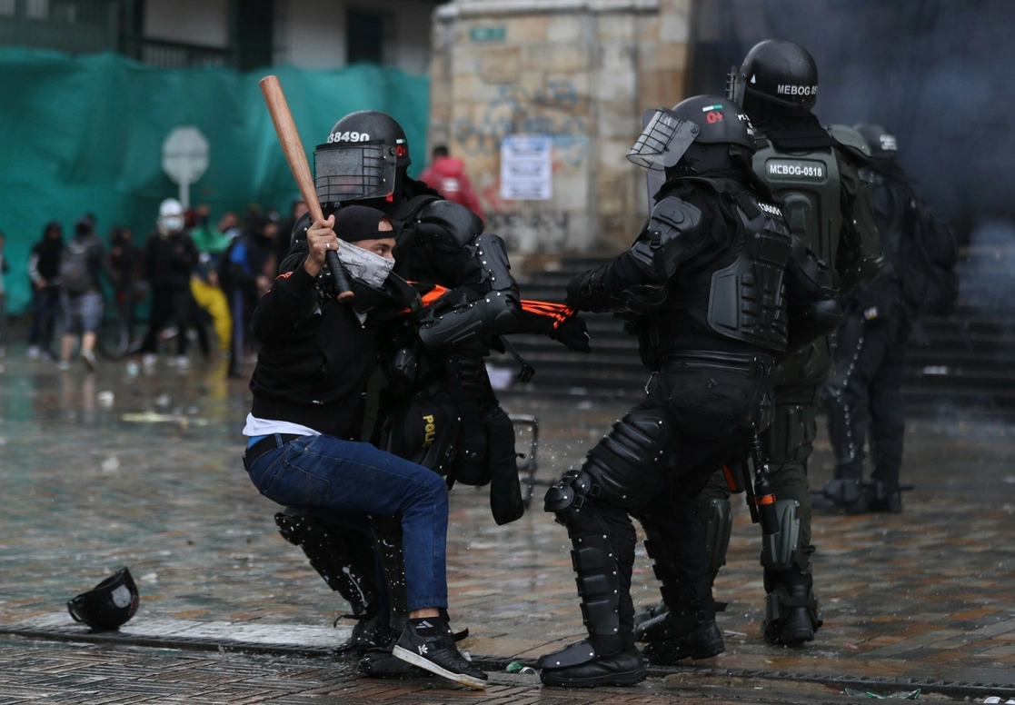 Un joven se enfrenta a la policía durante las protestas sociales en Colombia, en mayo de 2021. Foto Ap