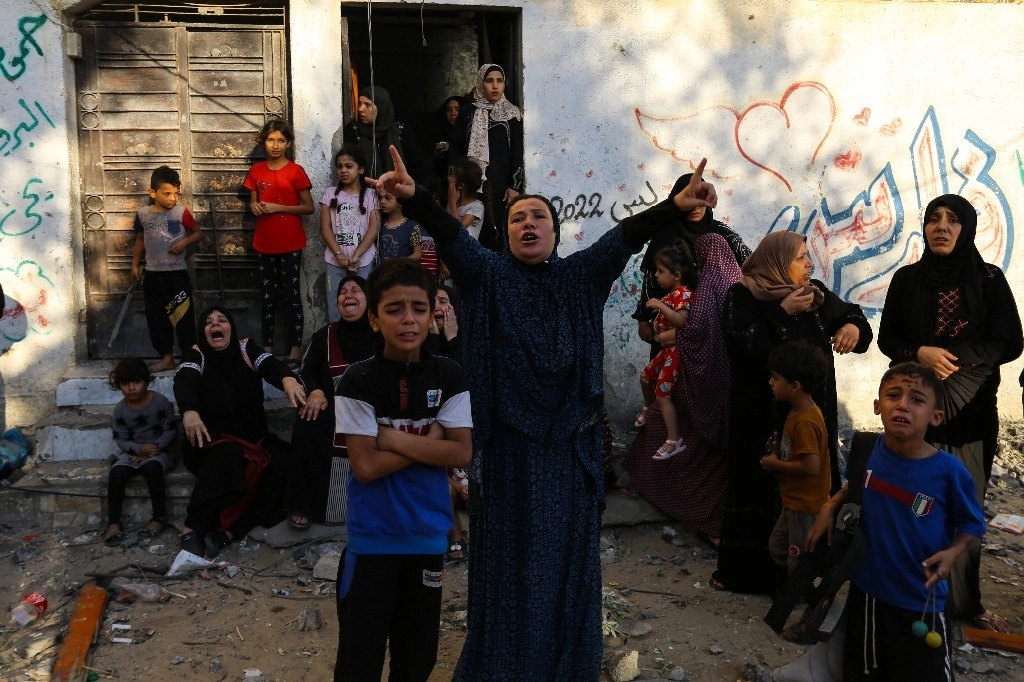Mujeres y niños palestinos reaccionan tras los ataques aéreos israelíes contra su vecindario en la ciudad de Gaza, el sábado 21 de octubre de 2023. Foto Ap