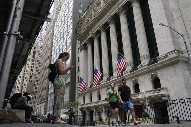 Personas caminan frente a la sede de la Bolsa de Valores de Nueva York. Foto Ap

