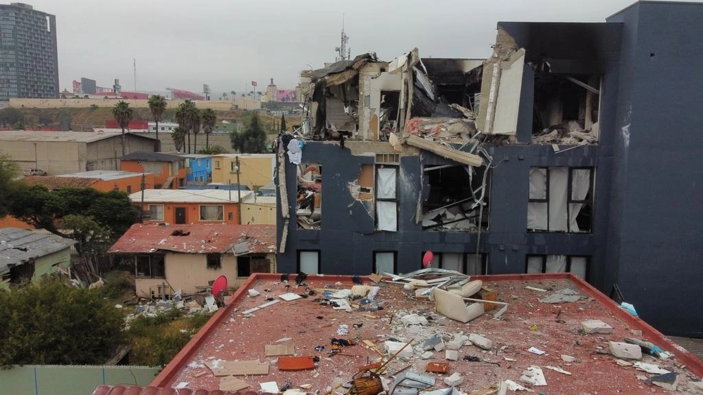 Parte de la estructura de los departamentos afectados salió proyectada y afectó vehículos y casas aledañas. Foto Omar Martínez / La Jornada Baja California