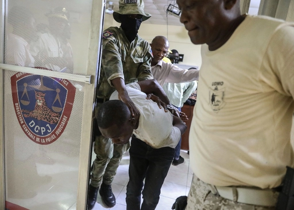Un agente de la Policía Nacional controla a un detenido esposado durante un operativo contra el crimen en Puerto Príncipe, Haití, el viernes 16 de agosto de 2024. Foto Ap