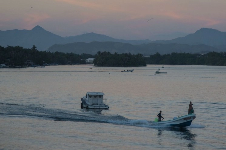 Pescadores realizan su actividad durante el atardecer en el Puerto Lázaro Cárdenas, Michoacán. Foto Cuartoscuro / Archivo