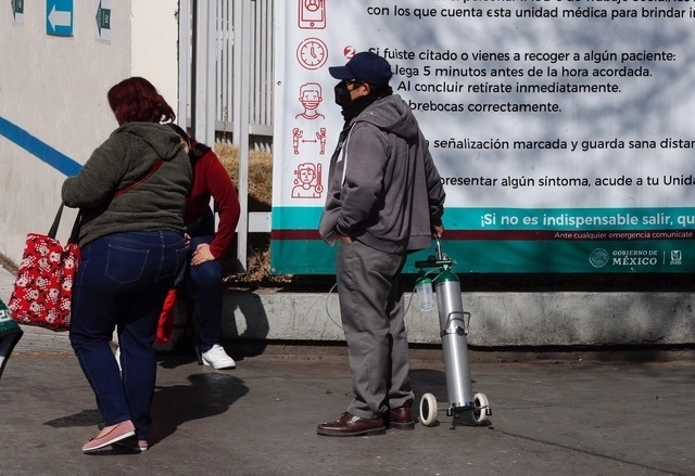 Hombre transporta un tanque de oxígeno medicinal. Foto Cristina Rodríguez