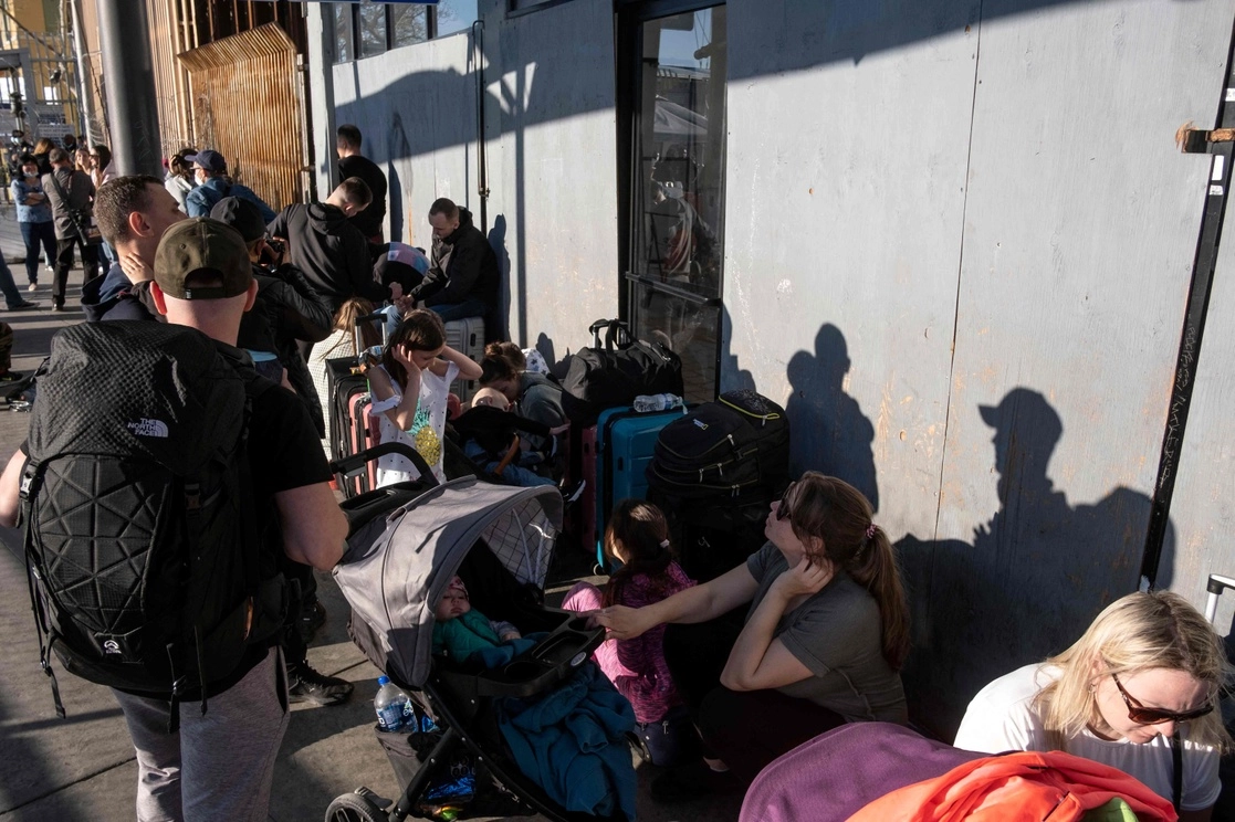 El grupo creció en las últimas horas a raíz de que se ha difundido en Europa que Estados Unidos recibirá a cientos de ciudadanos de Ucrania que huyen de la invasión rusa, según comentan los recién llegados a Tijuana. En la imagen, ucranios en el lado mexicano de la garita de San Ysidro, el pasado 24 de marzo de 2022. Foto Afp