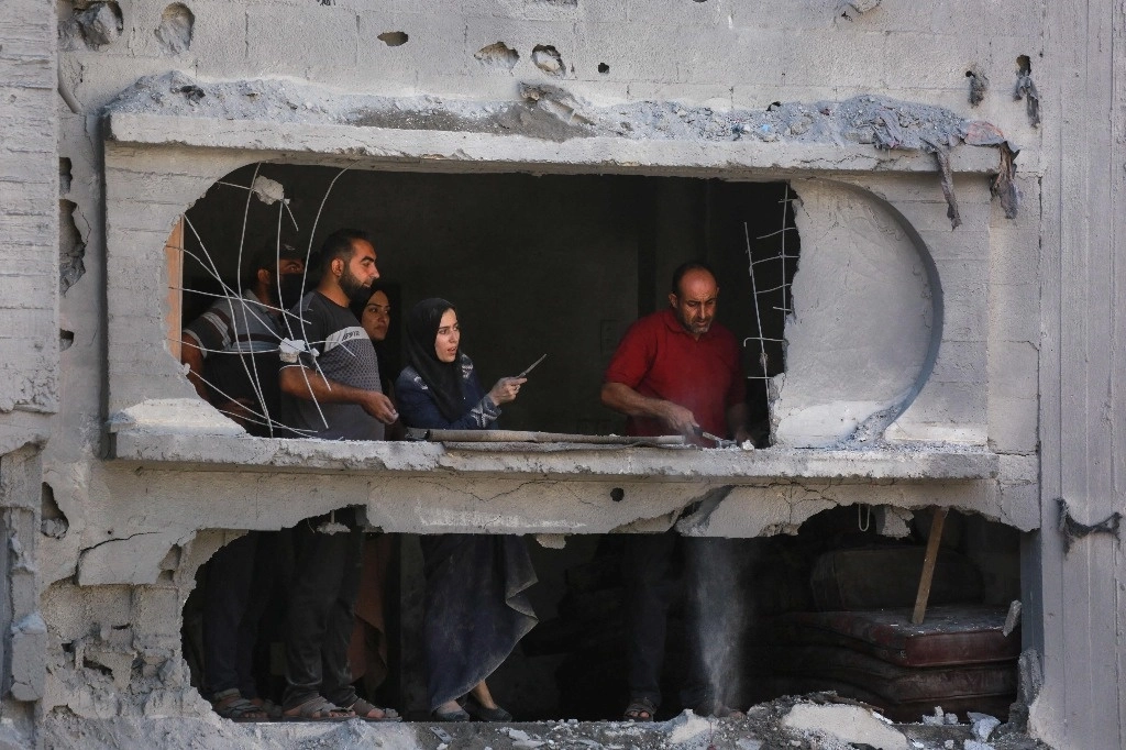 El ejército israelí anunció esta semana una pausa de los combates a lo largo de la ruta protegida en horario diurno. En la imagen, un grupo de palestinos, en el campamento de refugiados de al-Bureij, en el centro de la franja de Gaza, el 18 de junio de 2024. Foto Afp
