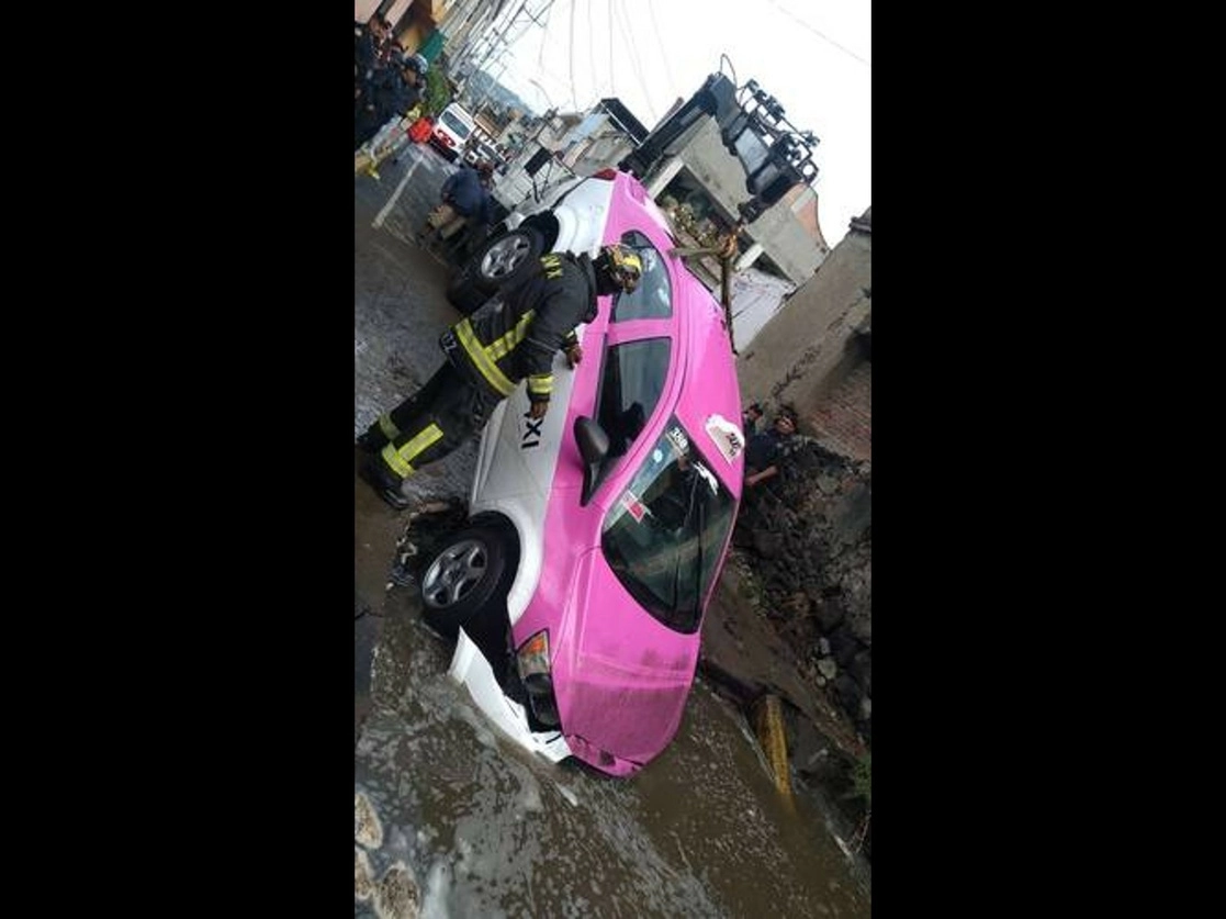 La torrencial lluvia de la madrugada del lunes ocultó un socavón de más de dos metros de profundidad que se formó en el cruce de las calles Javier Mina y Agustín de Iturbide, en el pueblo de San Antonio Tecómitl, en Milpa Alta, donde un taxi cayó y fue necesaria una grúa de la Secretaría de Seguridad Ciudadana para recuperarlo. Foto ‘La Jornada’