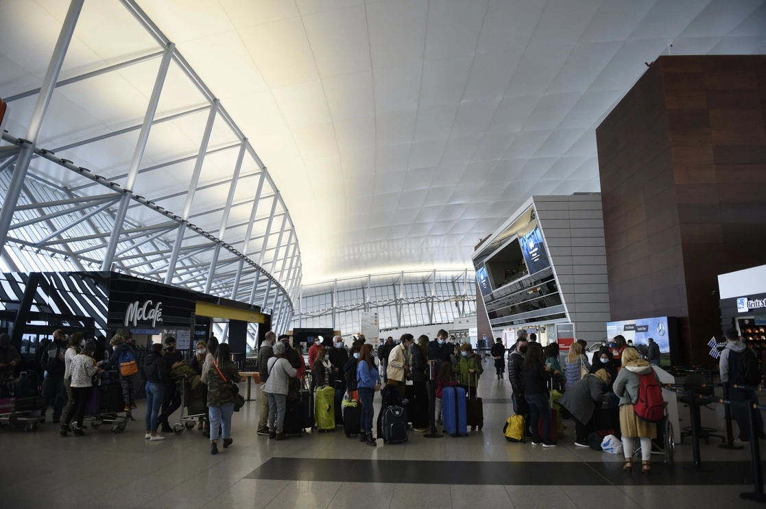 Personas esperan con sus maletas previo a registrarse para abordar un vuelo en el Aeropuerto Internacional de Carrasco, en Montevideo. Foto Xinhuua