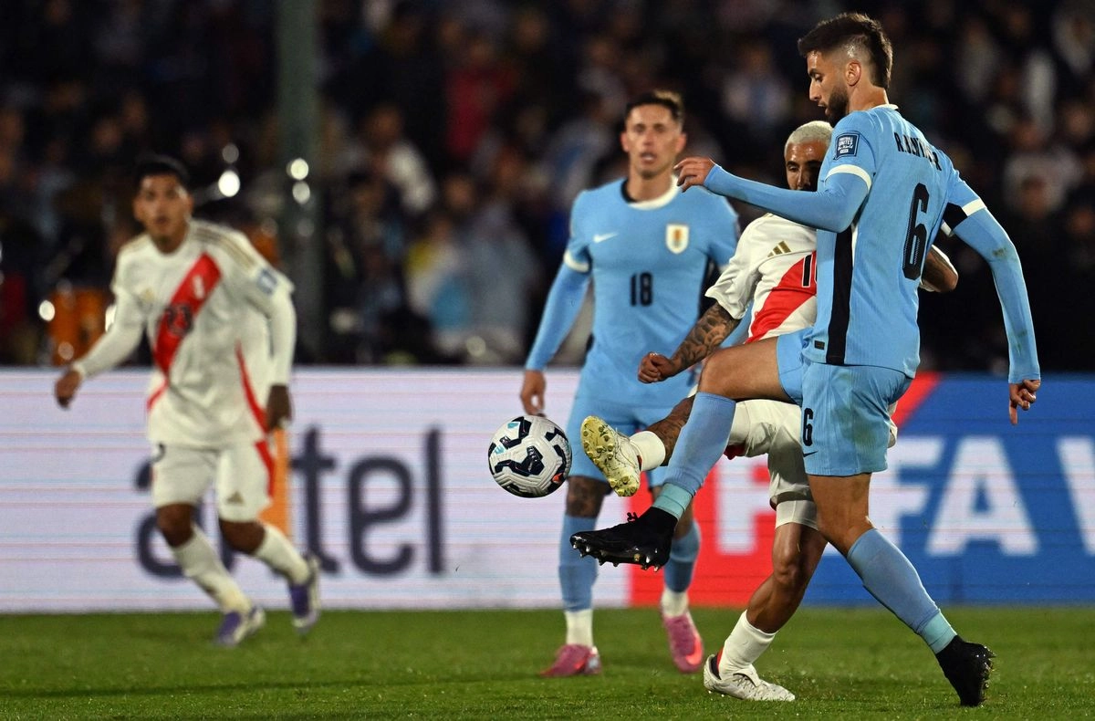 El mediocampista peruano Sergio Peña y el mediocampista uruguayo Rodrigo Bentancur disputan el balón durante el partido de clasificación sudamericana para la Copa Mundial de la FIFA 2026 entre Uruguay y Perú en el estadio Centenario de Montevideo el 4 de septiembre de 2025. Foto